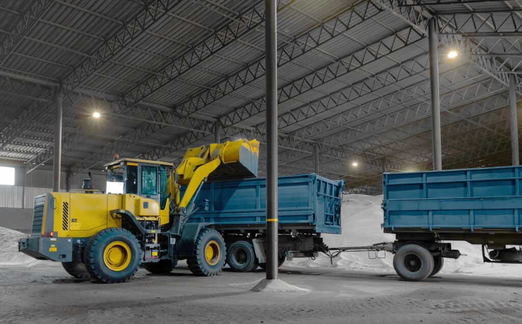 Gravel being loaded inside a warehouse, showing bulk material handling