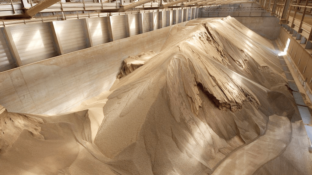 Large stockpiles of bulk material stored in a warehouse, ready for accurate stockpile inventory measurement and management.